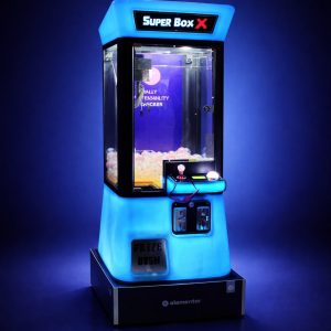 מכונת משחק מנוף בובות (Claw Machine) מוארת בלד כחול, מוצבת בביתן בכנס עסקי